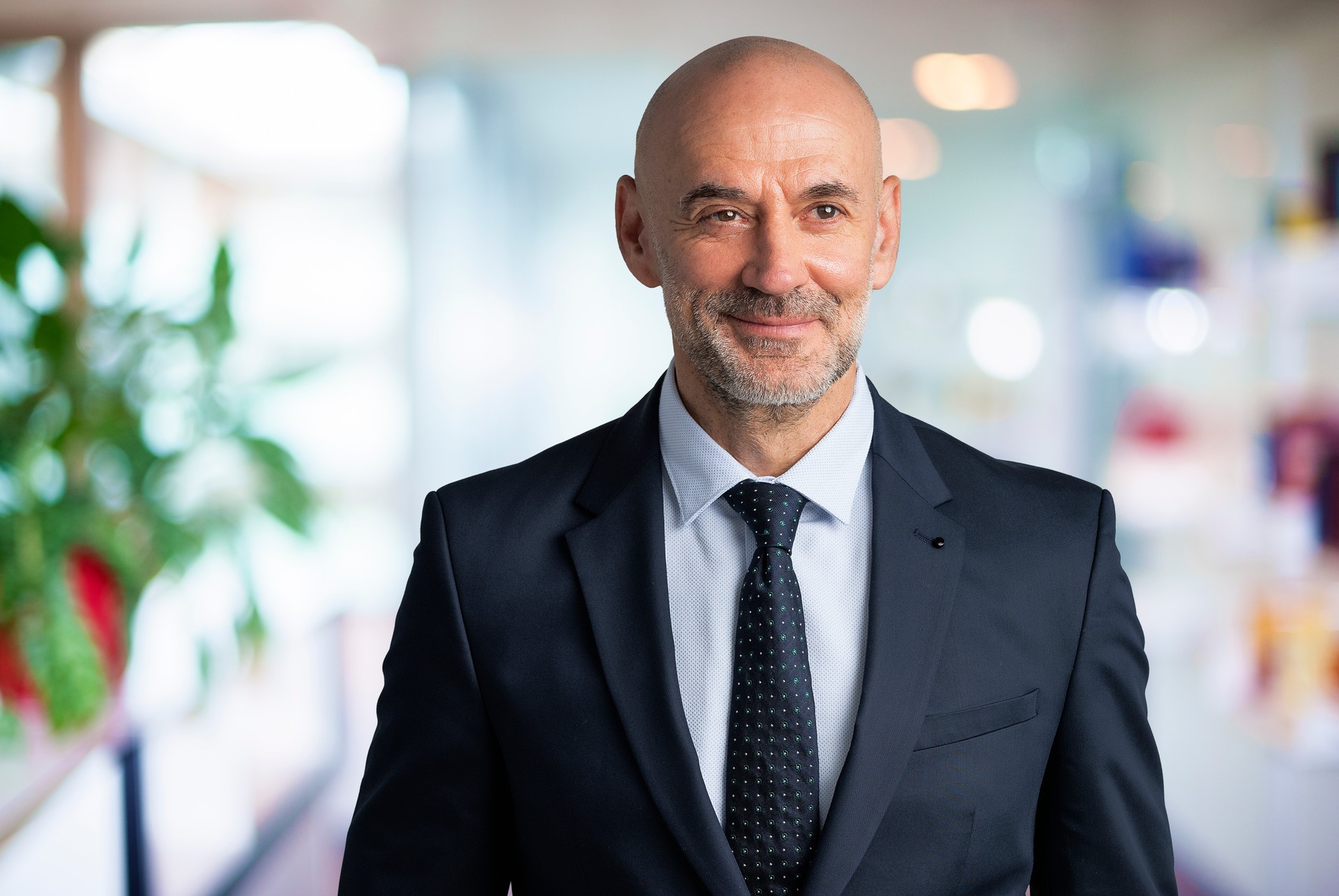 Mid aged businessman wearing suit and standing at the office lobby